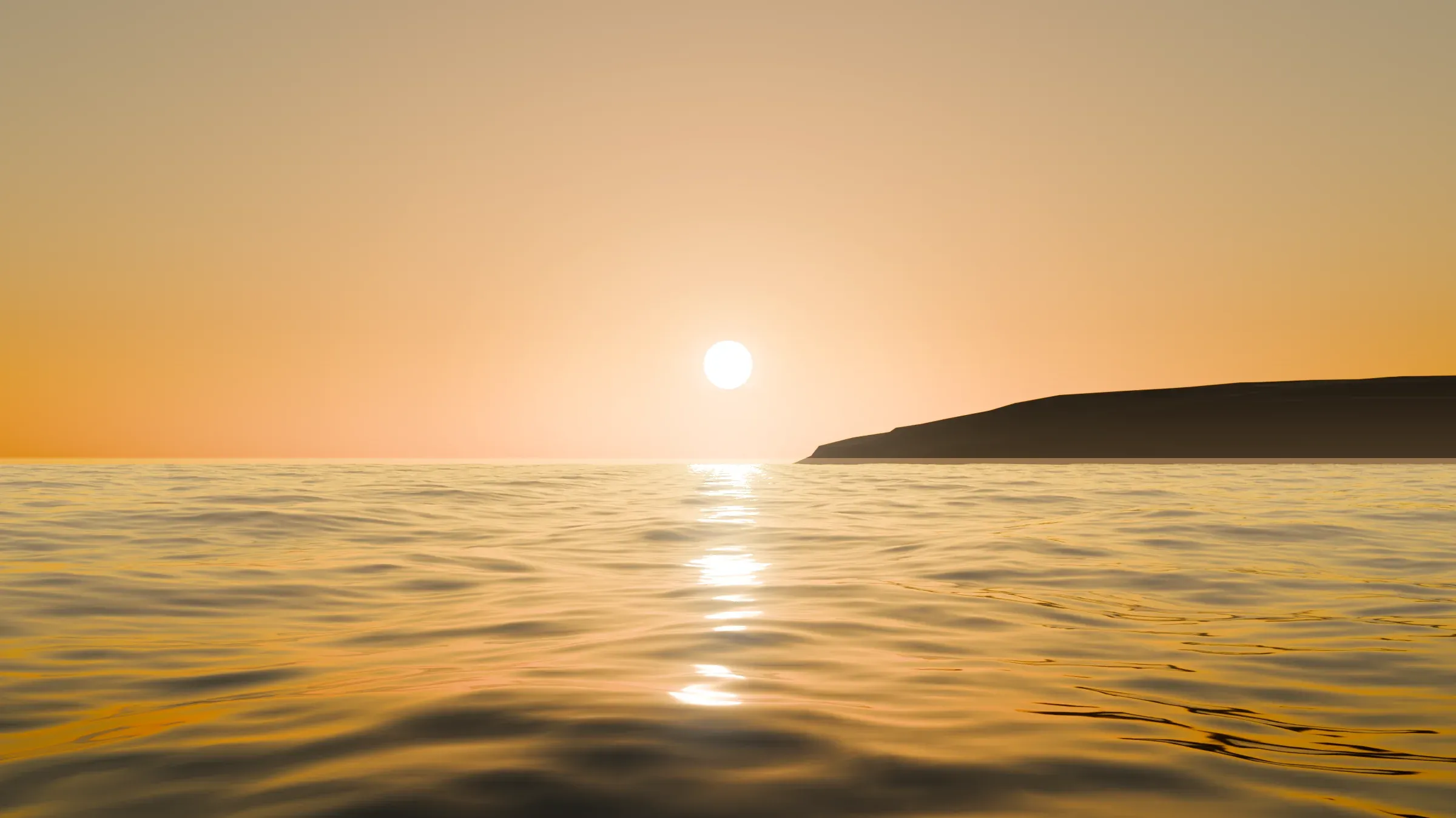 The sun low over the Pacific with a bright glitter path and haze on the water, a dark headland on the right