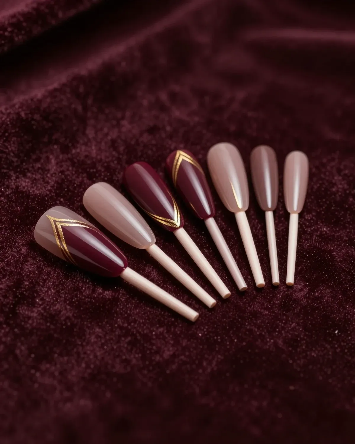 Almond nail tips in wine and smoky taupe with gold chrome lines